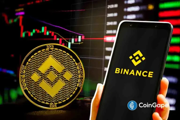 Smartphone exibindo logo da Binance ao lado de moeda física com símbolo da Binance, com gráficos de preço de criptomoedas ao fundo.