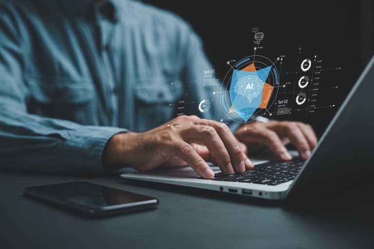 Foto de stock de A IA ajuda a gerar negócios com automação inteligente e um sistema BPA, enquanto um empresário em sua mesa usa um laptop para dar instruções à IA, conduzindo a automação de processos com eficiência