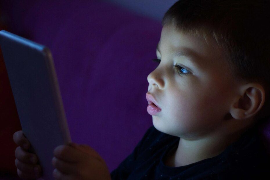 Garoto com tablet no escuro; inteligência artificial